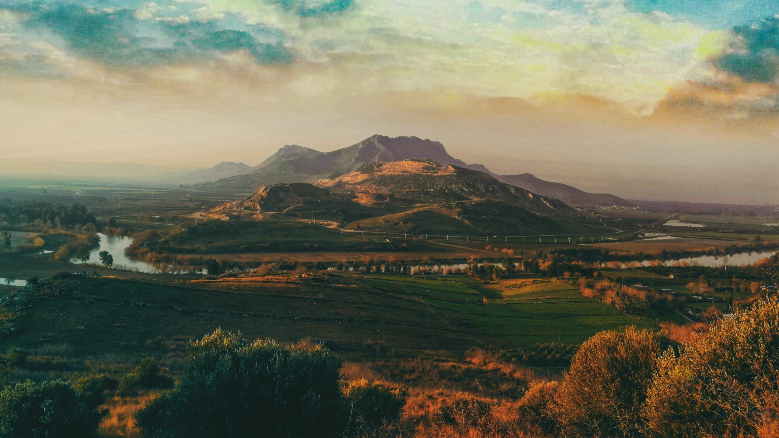 Breathtaking landscape of Şehitkamil, Gaziantep featuring mountains, farmland, and a tranquil river.